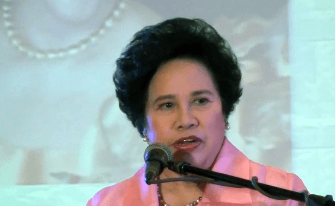 Miriam Defensor Santiago speaking into a microphone at a podium.